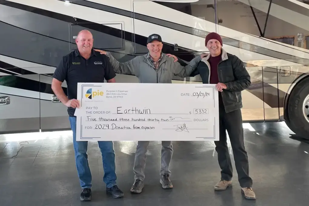 The Beaver Coach Sales team holding an oversized donation check